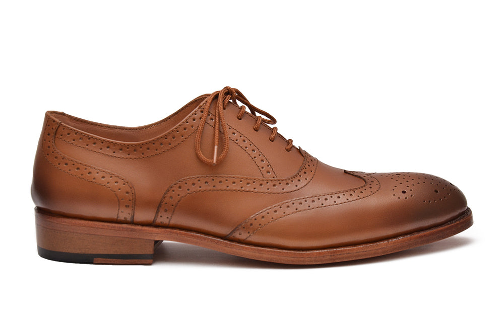 Brown leather brogue shoe on a white background