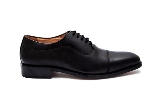Black leather dress shoe on a white background