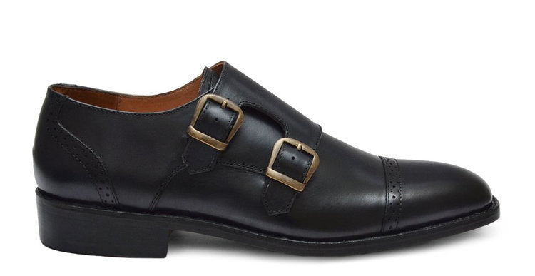 Black leather dress shoe with gold buckles on a white background